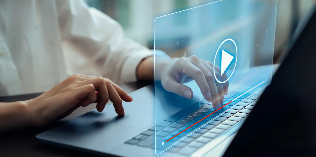 Hands typing on laptop with virtual video player interface – Online media streaming and digital content creation concept.