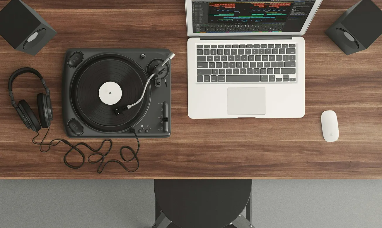 A wooden desk with a turntable, headphones, and a laptop showing audio software. Speakers are placed on either side, conveying a music production setup.