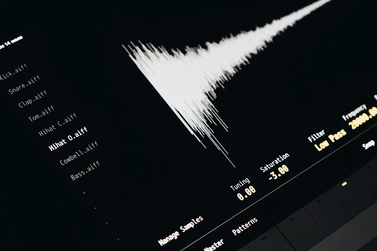 Close-up of a digital audio interface displaying a waveform on the right and a list of sound files on the left. The mood is technical and focused.