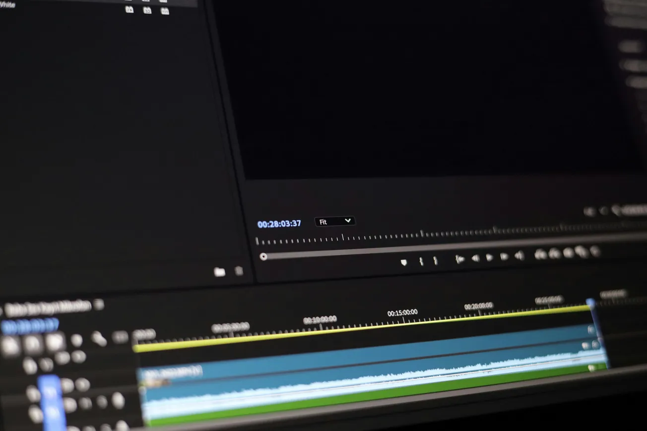 Close-up of a video editing software interface showing a timeline with audio and video tracks layered horizontally, set in a dark mode theme.