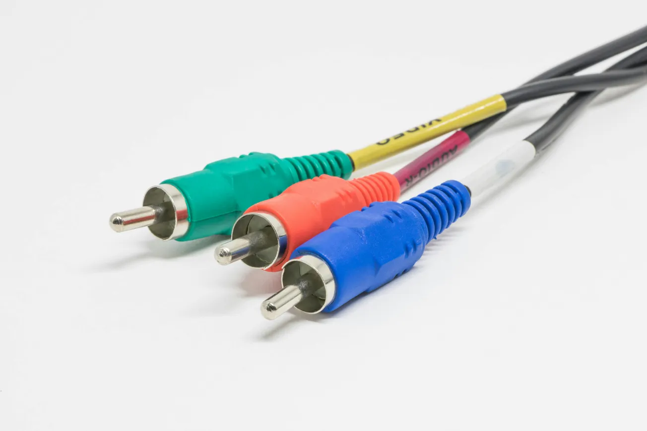 Three RCA cables with green, red, and blue connectors lie side by side on a white background. The cables are neatly aligned, emphasizing audio-video connectivity.