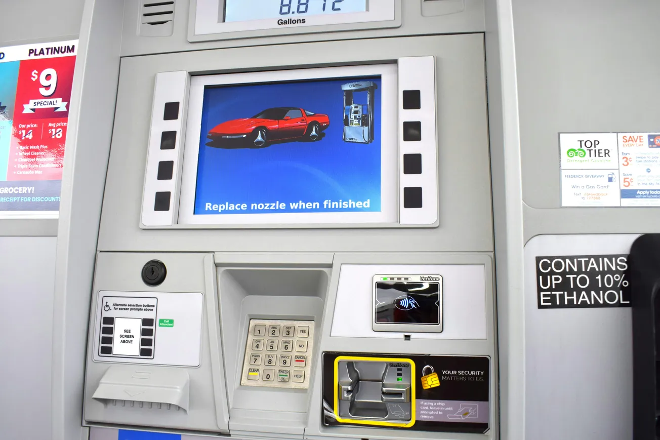 Gas station pump interface displaying a screen with a red sports car. Includes keypad, card reader, and ethanol notice. Modern and functional.