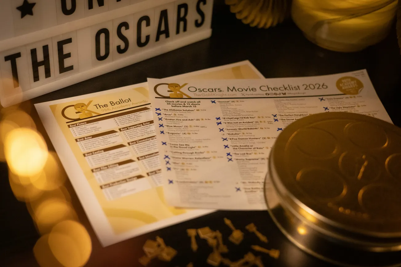 Illuminated Oscars-themed setup with a 2026 movie checklist and ballot papers on a table. A marquee reads "THE OSCARS," creating an elegant ambiance.