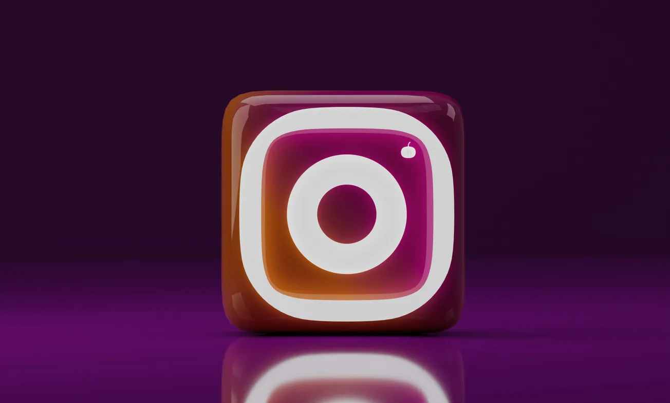 3D-rendered Instagram logo with a glossy finish, set against a dark purple background. The logo’s vibrant gradient reflects against a polished surface.